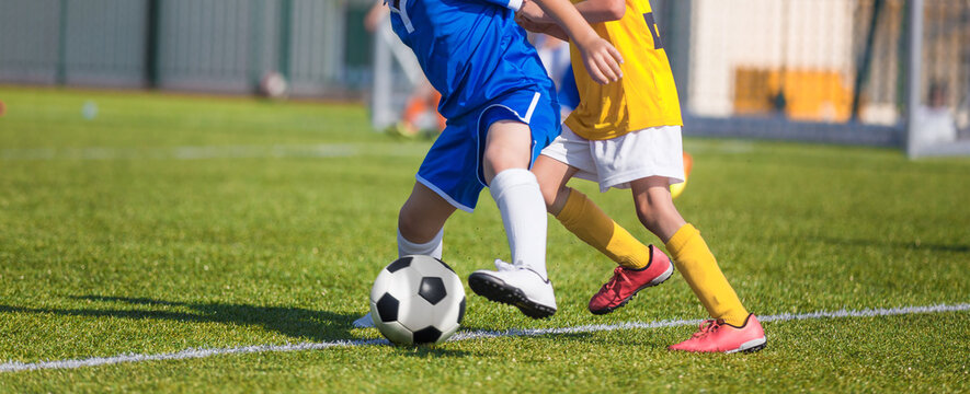 Football Players Compete For a Ball. Children Playing Sports on Grass Pitch. Two Kids in Soccer Duel on Sideline. Closeup Image of Youth Football Competition Match