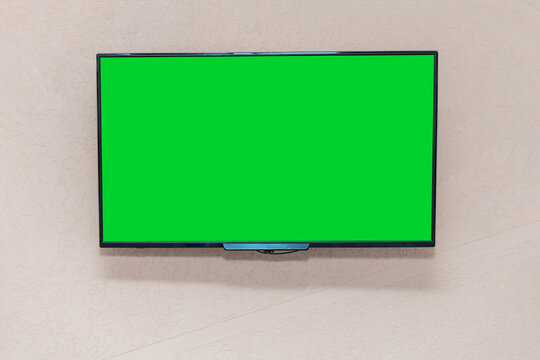 Large modern TV set with wide screen with green empty chromakey space