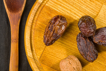 Big luxury dried date fruit on the wooden board, kurma ramadan kareem concept, close up.
