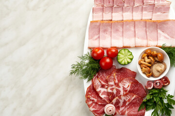 Assortment of meat on a platter with ham and mushrooms. Copy space.