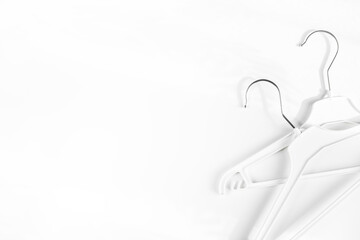 Two white lothes hangers on a white background. Flat lay, copy space, horizontal background. Clothes hangers , shopping concept, sales. Header, banner for site design. 