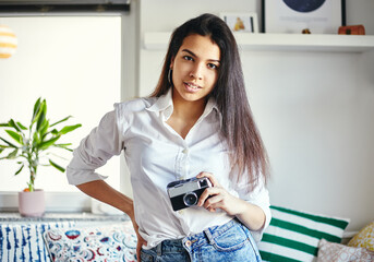 Urban fashion young girl holding retro film camera.