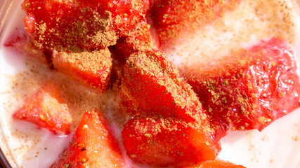 Strawberries with cinnamon and milk in the sun