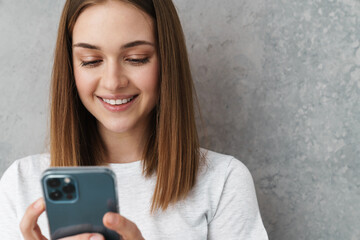 Happy nice charming girl smiling and using cellphone