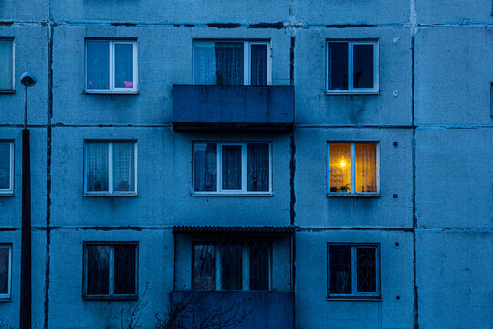 Wall of multi-storey residential building with Iluminated window.