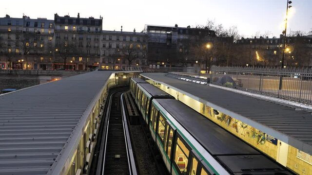 The metropolitan at Bastille station with the facades of parisian buildings in the background.  winter 2021, Paris, France.