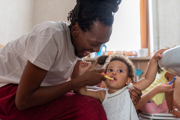 morning ritual, african daddy helping her daughter and teaching how to brush her teeth, rasta...
