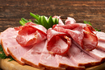 Pieces of appetizing coppa on a wooden background, still life composition.