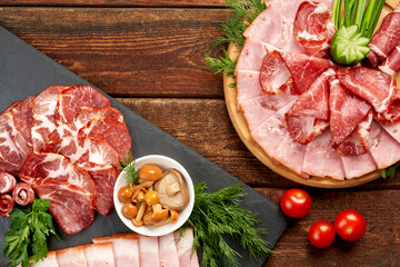Top view on sliced ham on a slate with mushrooms, and cherry tomatoes. Appetizing snacks. Still life of Parma ham.