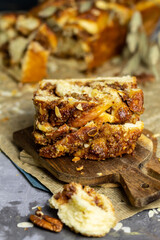 Homemade braided cake Babka with pecan nuts and cinnamon on craft paper. Easter sweet pastry. 