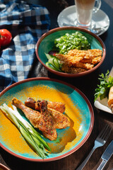 Fried chicken legs with green onions and spices on the table in a beautiful arrangement