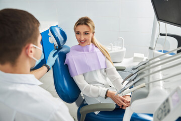 Female in dental chair asking her doctor