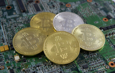 Golden coins with bitcoin symbol on a mainboard