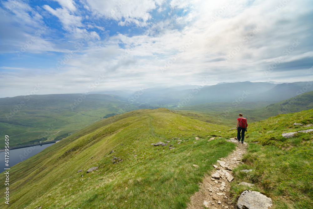 Poster A hiker walking down from Creag an Fheadain towards Loch Daimh in the Scottish Highlands, UK mountain landscapes.