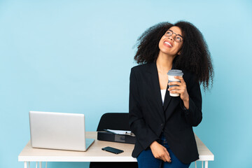 African american business woman working in her workplace looking up while smiling