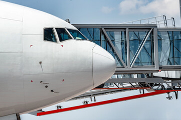 nose of airplane with boarding bridge