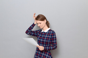 Portrait of disappointed young woman reading document