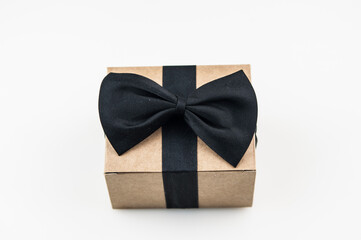 Craft gift box on a white background, decorated with a textured bow, creating a romantic luxury atmosphere. For birthday, anniversary presents, gift post cards.