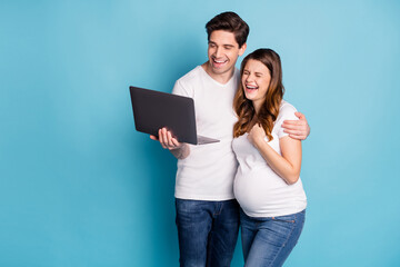 Photo of optimistic pregnant couple laugh laptop wear white t-shirts isolated on cyan color background