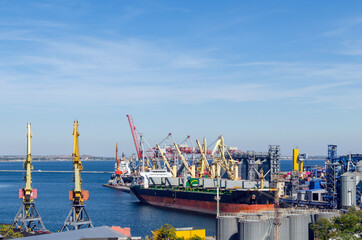Port cargo crane loads a container onto a cargo ship in a seaport