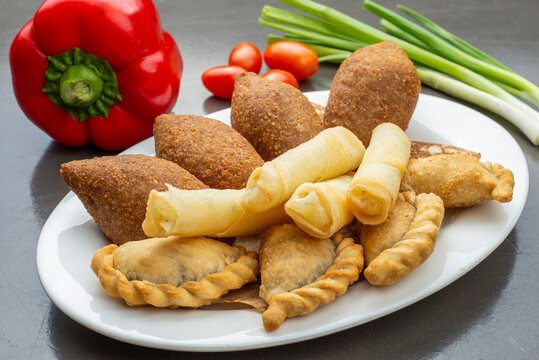 Lebanese Plate of Kebbeh, cheese rolls and meat pie isolated on white.