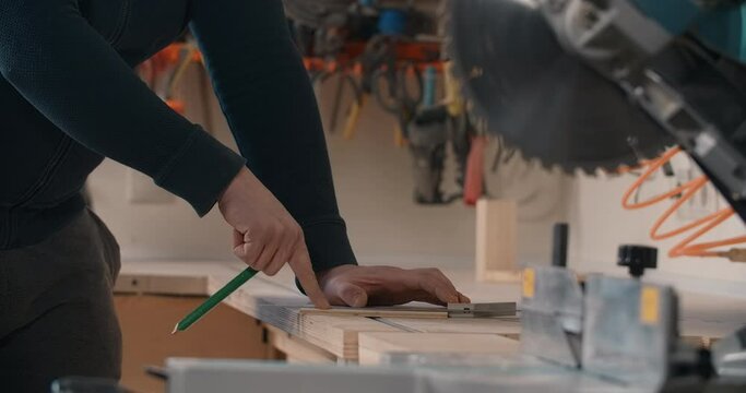 Carpenter marks out a plywood block before cutting it, furniture manufacturing, woodworking at craftsman's workshop, 4k 60p Prores 422 HQ 10 bit