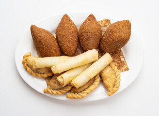 Lebanese Plate of Kebbeh, cheese rolls and meat pie isolated on white.