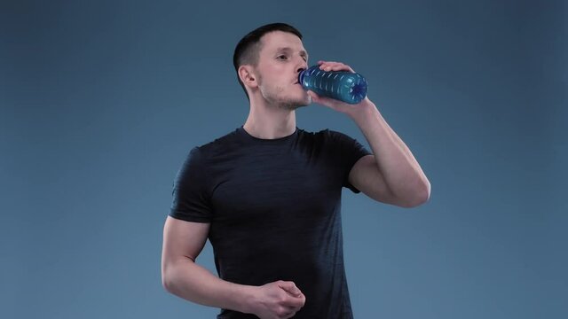 Sportsman Drinking Sport Drink. Man Drinking BCA Before Traning. Man Having a taste of Sport Drink.