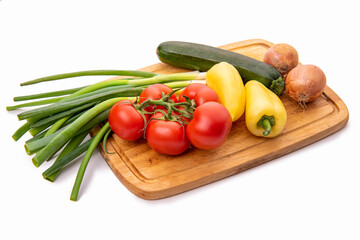 Vegetables on a cutting board. Tomatoes, onions, yellow paprika and zucchini. Isolate on white background