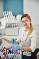 Caring dentist getting ready to write notes about patient health