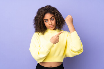 Young African American woman isolated on background making the gesture of being late