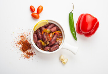 Lebanese starters of Sausage meat marinated, sausages fried in a metal pan isolated on white.