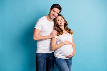 Photo of cheerful charming adorable family waiting baby hugging arms hands tummy isolated blue color background