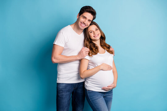 Photo of cheerful charming adorable family waiting baby hugging arms hands tummy isolated blue color background