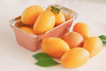 Big size fresh ripe organic sweet yellow marian plum or plum mango compare with egg on white background. Tropical exotic summer fruit call Mayongchid or Maprang in Thailand with sweet and sour taste.