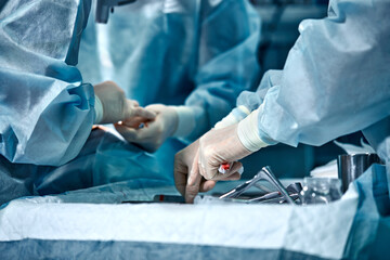 Hands of a team of surgeons close-up in the operating room during the operation, sterile...