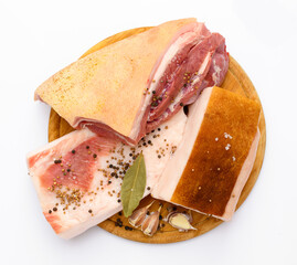 raw pork meat and lard with salt, spices and garlic on a cutting board, white background