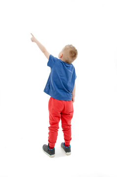 Back view of little boy points at wall. Rear view. Isolated on white background 
