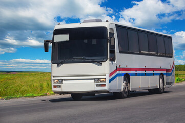 Fototapeta na wymiar Tourist bus moves along a country road