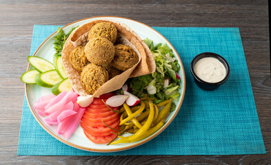 Vegetarian dish - falafel balls from spiced chickpeas with veggies and tartar sauce.