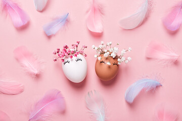 Obraz na płótnie Canvas White and black Easter eggs with natural flowers wreath on soft pink feathers background. Zero Waste Easter Concept. Racial Equality symbol