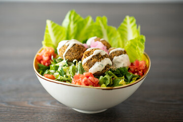 Falafel Salad Vegetarian dish - falafel from spiced chickpeas on wooden rustic table..