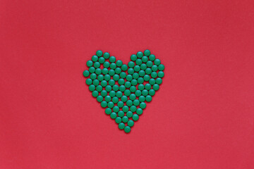The heart laid out from the vitamin lies on the background. Pills in the form of the word love are on the table. High quality photo