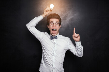 Excited smart man with light bulb pointing up