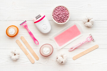 Obraz na płótnie Canvas Flat lay of pink epilator with wax strips and razor. Spa cosmetic treatments.