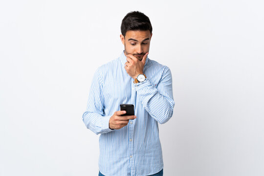 Young handsome man over isolated background thinking and sending a message