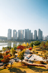Fototapeta premium View of modern skyscrapers and Gwanggyo Lake Park at autumn in Suwon, Korea