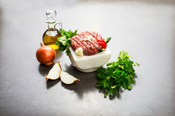 Lebanese food of Raw meat kibbe with oil and veggies.