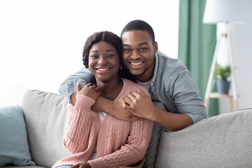 Fototapeta premium Portrait of happy black couple hugging at home