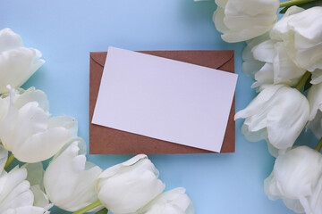 Obraz na płótnie Canvas mockup greeting card. beautiful bouquet of tulips and space for text. envelope and white blank 